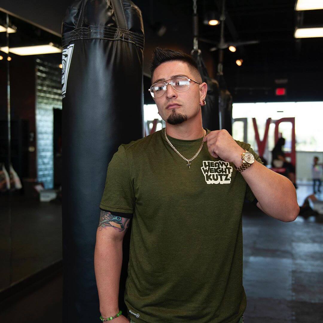 Client in an olive Heavyweight Kutz t-shirt by the heavy bag